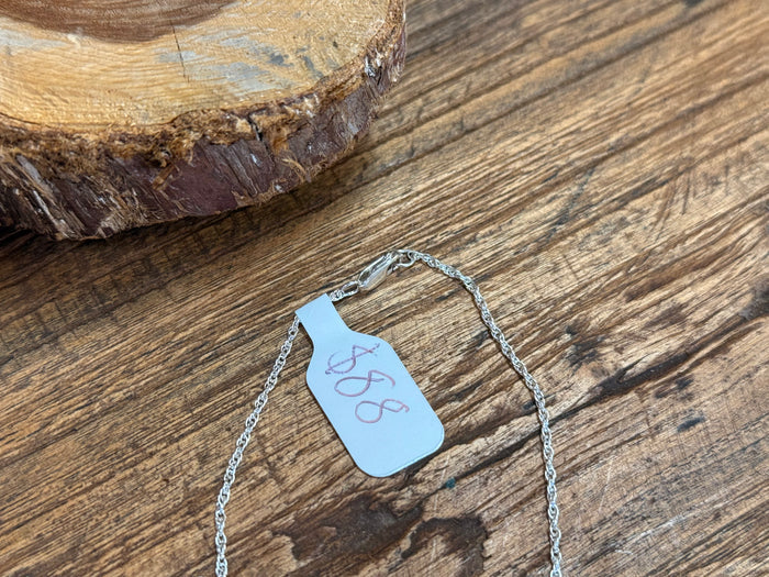 Turquoise horseshoe pendant necklace with silver-tone chain and attached price tag