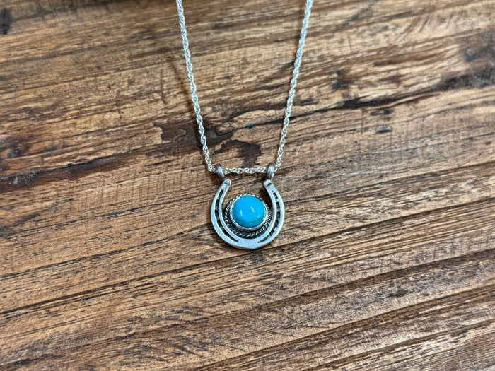 Turquoise horseshoe pendant necklace with layered metal design and small turquoise inlay