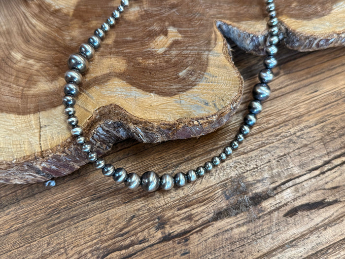 Sterling pearl necklace close-up of graduated bead strand and leaf pendant tip