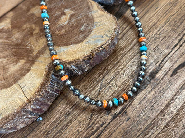 Turquoise and orange beaded necklace with small silver spacers, close-up detail