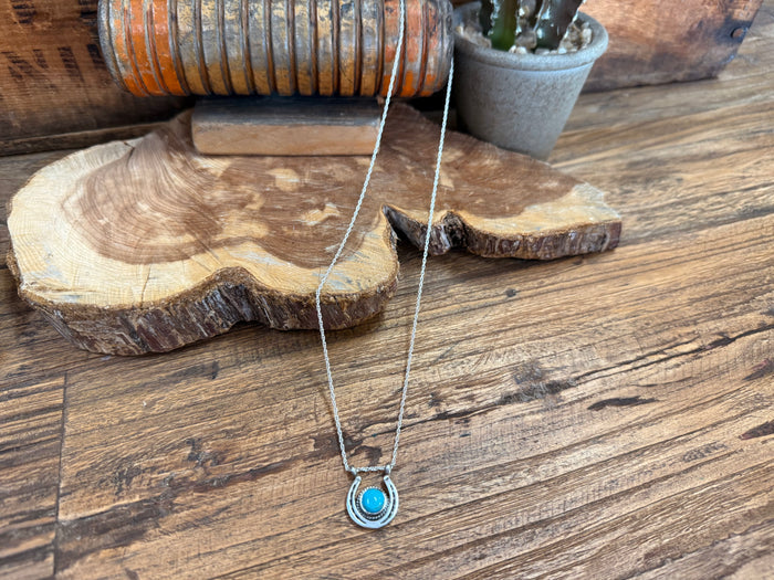 Turquoise horseshoe pendant necklace with silver-tone chain and round turquoise center