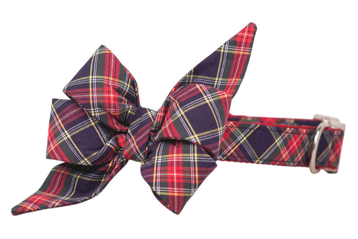 Festive red and navy tartan bow with long tapered ends, secured to a coordinating plaid dog collar fitted with a metal buckle.
