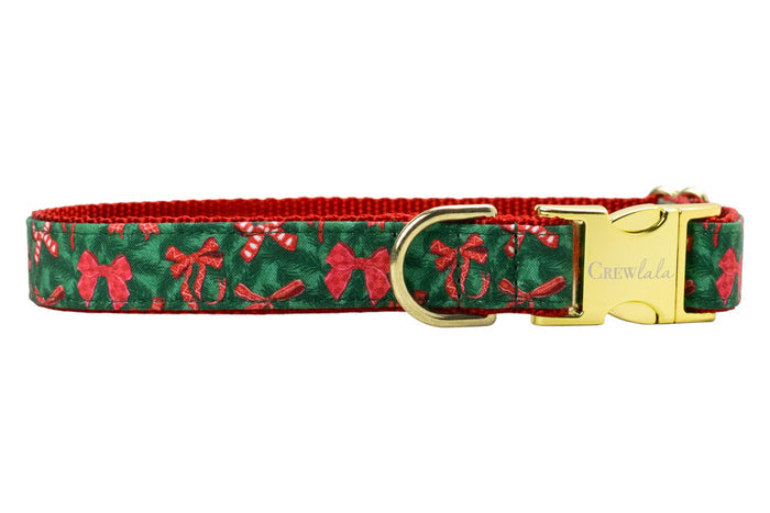 Festive dog collar featuring a pine green background patterned with bows and candy canes, stitched onto a nylon base. It includes polished hardware: a sleek side-release buckle engraved with “Crewlala,” a sturdy D-ring.