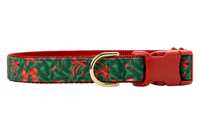 Festive dog collar featuring a pine green background patterned with bows and candy canes, stitched onto a nylon base. It includes polished hardware: a plastic side-release buckle engraved with “Crewlala,” a sturdy D-ring.
