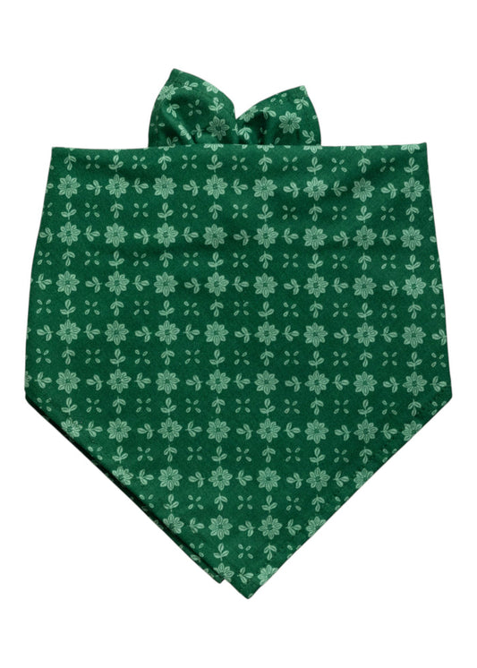 Dog bandana made from deep green fabric patterned with evenly spaced light green floral motifs. The floral design consists of daisy-like blooms arranged in neat vertical and horizontal rows.