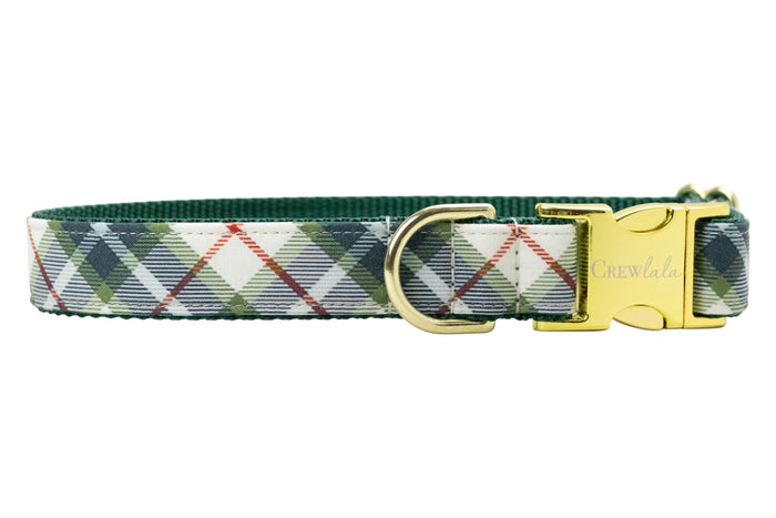 Adjustable dog collar featuring a light base with an olive green tartan plaid pattern, accented by thin diagonal lines. The collar has durable green webbing on the underside, a metal D-ring, and a polished quick-release buckle engraved with the brand name “Crewlala.”