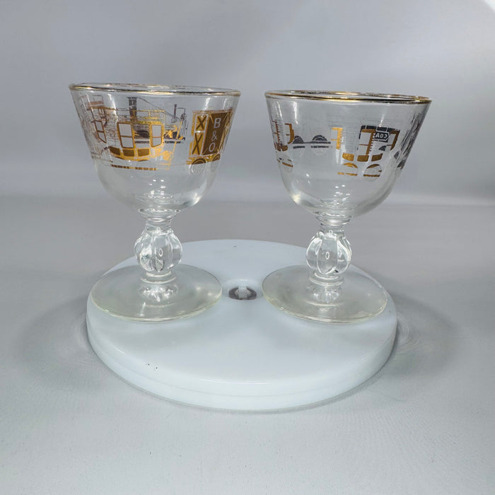 Set of two vintage Libbey American Antiques B&O Railroad footed cordial glasses with gold train illustrations and gold rim.
