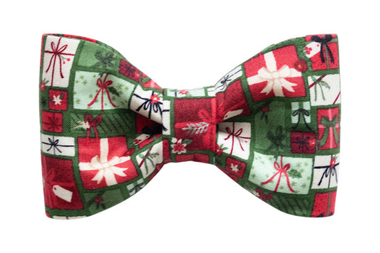 Classic dog bow tie in a Christmas gift box print wrapped with contrasting bows and tags. The bow tie’s structured design keeps its shape, making it a standout holiday accessory for a collar.
